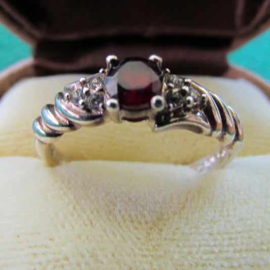 925 Sterling Silver Dress Ring Set With A Garnet Having Clear Shoulder Stones