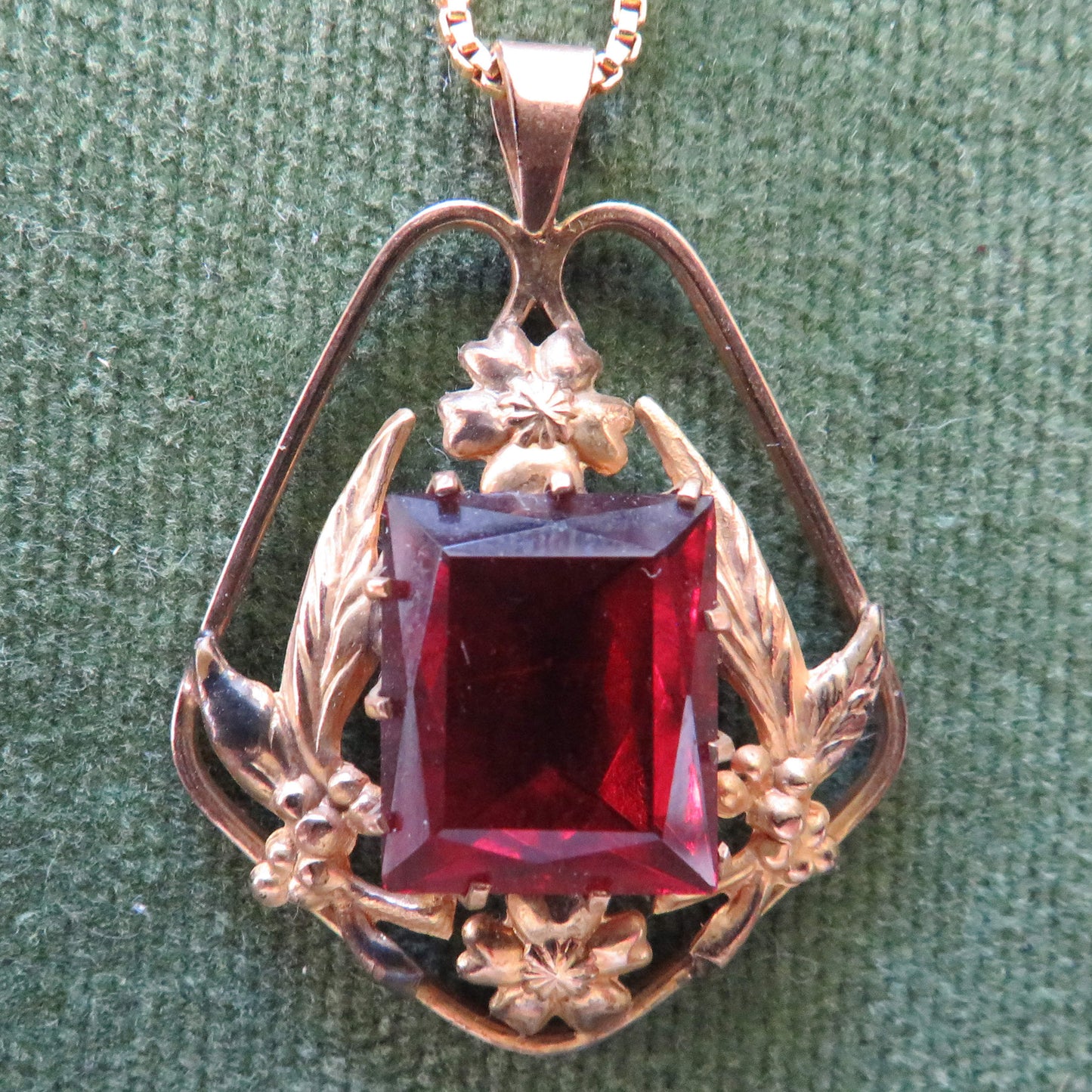 Gold Lined Pendant With Foliate Decorated Border Set With A Large Oblong Mixed Cut Red Claw Set Paste Simulate