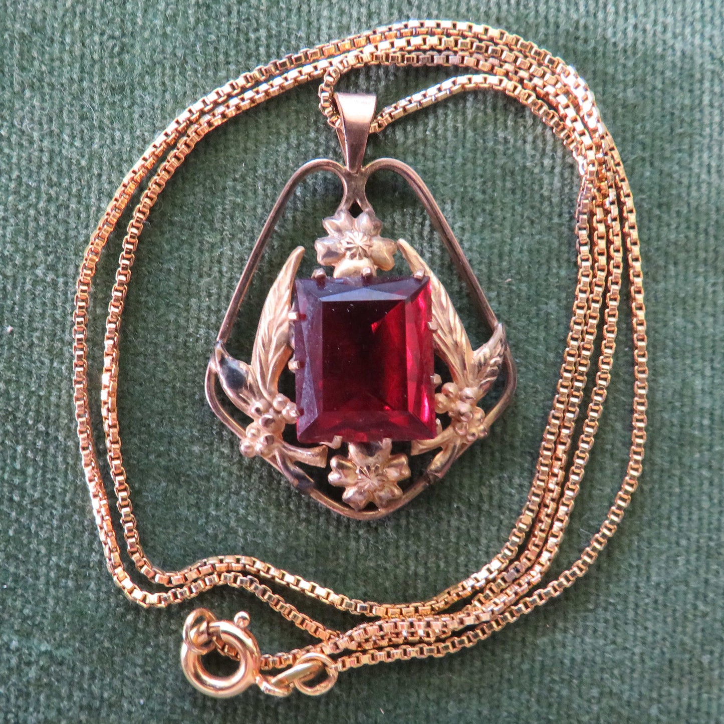 Gold Lined Pendant With Foliate Decorated Border Set With A Large Oblong Mixed Cut Red Claw Set Paste Simulate