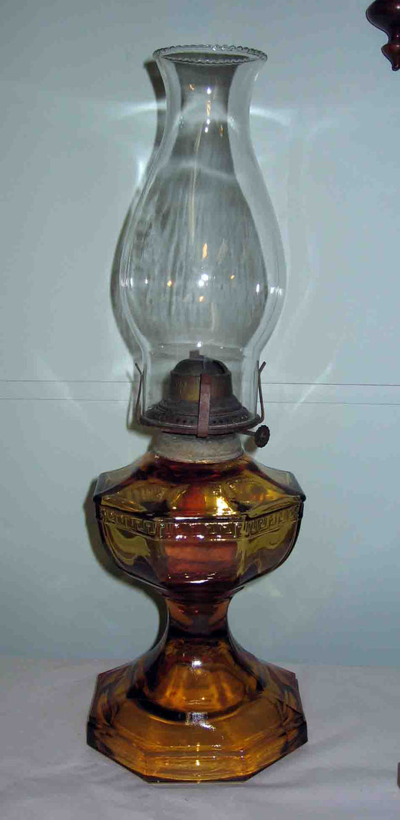 Greek Key pattern single burner oil lamp with amber glass font.